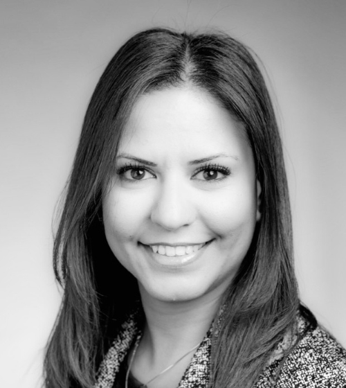 Black and white headshot of a woman with straight, shoulder-length hair, smiling at the camera against a plain background.