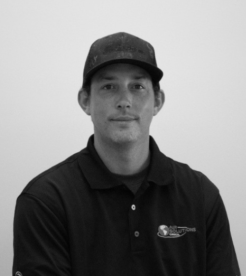 A man wearing a dark polo shirt with an "Air Solutions" logo and a dark baseball cap sits against a plain background.